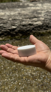 Magic Mag magnet resting in an open palm beside a creek