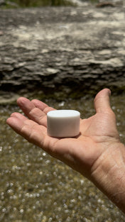 Pocket Mag magnet resting in an open palm beside a creek