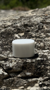 Pocket Mag matte white magnet puck on a limestone creek rock